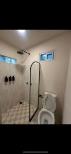 a bathroom with a shower and a toilet at La Punta surfhouse in Puerto Escondido