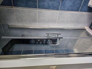 a whisk on the wall of a tiled bathroom at Ti harmoniel in Guingamp