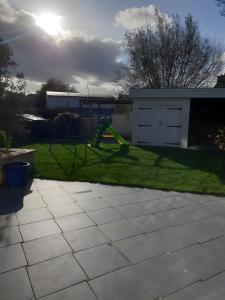 a yard with a swing set and a playground at Ti harmoniel in Guingamp +2 photos
