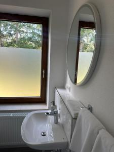 a white bathroom with a sink and a mirror at Pension Zollhaus in Oy-Mittelberg