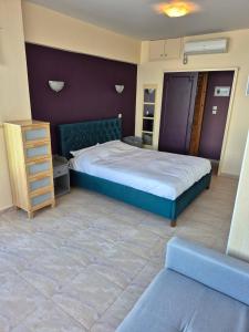 ルートラキにあるAtlas on the water - Loutrakiのベッドルーム1室(大型ベッド1台、青いヘッドボード付)