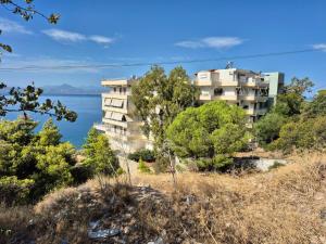 ルートラキにあるAtlas on the water - Loutrakiの水の横の丘の上の建物