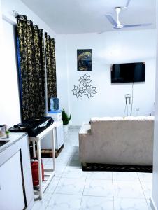 a living room with a couch and a tv at Talla Homes in Mombasa