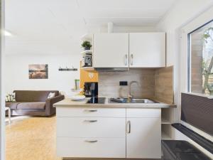 Una cocina con gabinetes blancos y un fregadero. en Campingplatz Wusterhausen, en Wusterhausen