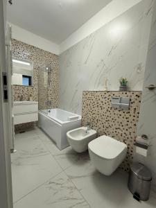 a bathroom with a toilet and a tub and a sink at Premium Apartment in Craiova