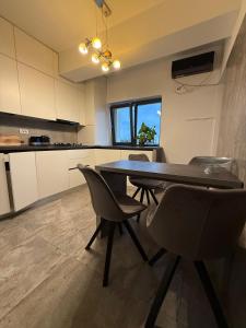 a kitchen with a dining room table and chairs at Premium Apartment in Craiova