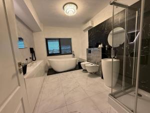 a bathroom with two toilets and a tub and a sink at Premium Apartment in Craiova +24 photos