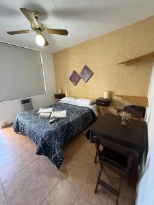 a bedroom with a bed and a table with a projector at Apart Hotel El Molino de la Costa in Villa Carlos Paz