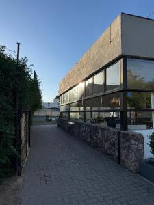 a building with a stone wall next to a street at Apart Hotel El Molino de la Costa in Villa Carlos Paz +21 photos