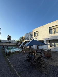 a group of chairs and umbrellas in front of a building at Apart Hotel El Molino de la Costa in Villa Carlos Paz