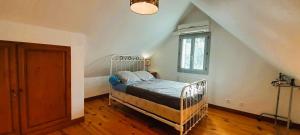ein Schlafzimmer mit einem Bett im Dachgeschoss mit einem Fenster in der Unterkunft Baudres jolie maison 6-8 pers jardin pisicne wifi in Baudres + 53 Fotos