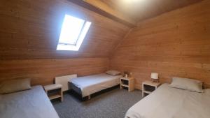 a room with two beds in a wooden cabin at Inčukalna Strops in Inčukalns