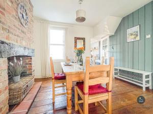 a dining room with a table and a fireplace at Harvest Moon - cottage close to harbour in Weymouth