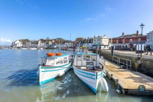 two boats docked at a dock in a harbor at Harvest Moon - cottage close to harbour in Weymouth +17 photos