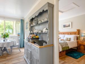 a bedroom with a bed and a room with a table at Paddock End in Great Plumstead +19 photos