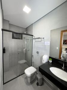 a bathroom with a shower and a toilet and a sink at Nature Bonito Hotel in Bonito