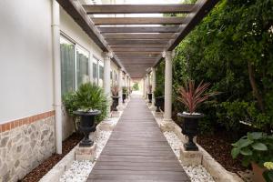 a walkway outside of a building with potted plants at Park Hotel Cellini in Lido di Jesolo