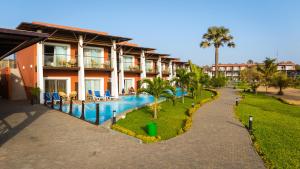 a resort with a swimming pool next to a building at African Princess Beach Hotel in Serekunda