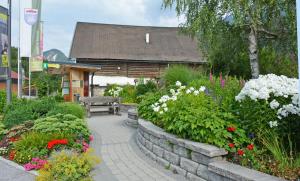 a garden with flowers and a bench in front of a building at Seilhof in Haus im Ennstal