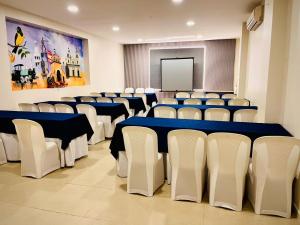 a conference room with blue tables and white chairs at Hotel Luxor Cúcuta in Cúcuta