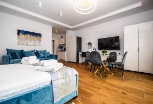a bedroom with a blue bed and a living room at Axxis Nova Beach in Mamaia