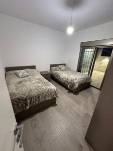 ein Schlafzimmer mit zwei Betten und einem Fenster in der Unterkunft Mtein view apartment 