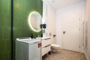 a bathroom with a sink and a mirror and a toilet at Axxis Nova Beach in Mamaia +7 photos