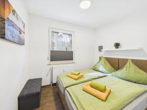Un dormitorio con una cama con sábanas verdes y una ventana. en Campingplatz Wusterhausen, en Wusterhausen