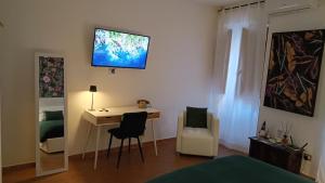 a bedroom with a desk and a bed with a television on the wall at Bilocale in Palazzo del XVI Secolo in Campobasso