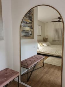 lustro w pokoju z łóżkiem i ławką w obiekcie ווילה בנאות לון w mieście Beer Szewa