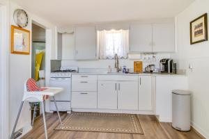 une cuisine blanche avec des armoires blanches et une table dans l'établissement Deck with Views Lakeside Spring Lake Cottage, à Spring Lake