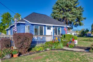 une maison bleue avec des drapeaux américains dans une cour dans l'établissement Deck with Views Lakeside Spring Lake Cottage, à Spring Lake