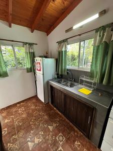 a kitchen with a refrigerator and a sink at La casita de Pablo in Santa Teresita