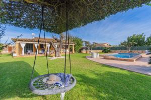 eine Schaukel mit Hut im Garten in der Unterkunft Villa Hortet den Joan By home villas 360 in Alcúdia