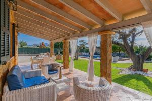 eine Außenterrasse mit Korbstühlen und Tischen in der Unterkunft Villa Hortet den Joan By home villas 360 in Alcúdia
