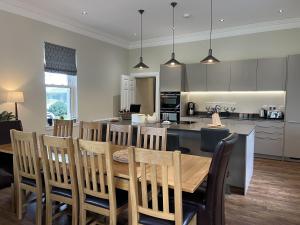 Una cocina y un comedor con mesa y sillas. en The Farmhouse at Solsgirth Home Farm, en Dollar 19 fotos más