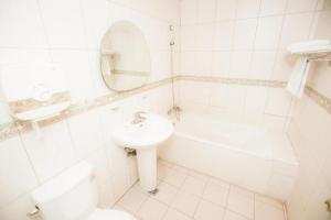 a white bathroom with a sink and a toilet and a mirror at Two Chung Hotel in Tucheng +24 photos