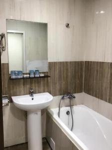 a bathroom with a sink and a bath tub next to a sink at Two Chung Hotel in Tucheng