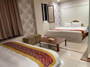 a hotel room with two beds and a table at Two Chung Hotel in Tucheng