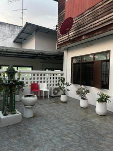 eine Terrasse mit Topfpflanzen vor einem Gebäude in der Unterkunft Wooden Friend House in Krabi