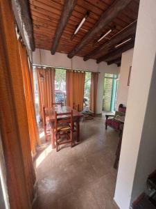 a dining room with a wooden table and chairs at La casita de Pablo in Santa Teresita