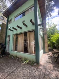 a green building with a window on the side of it at La casita de Pablo in Santa Teresita +45 photos