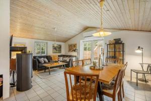 een eetkamer en een woonkamer met een houten plafond bij 10292-Ulfborg-Baekbyvej-15 in Øby