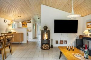 een woonkamer met een open haard en een tv aan de muur bij 10292-Ulfborg-Baekbyvej-15 in Øby