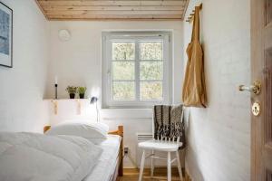 een slaapkamer met een bed, een raam en een stoel bij 10292-Ulfborg-Baekbyvej-15 in Øby