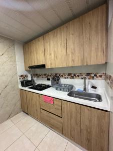 a kitchen with wooden cabinets and a sink at Guatavita Loft - Apartamento in Guatavita