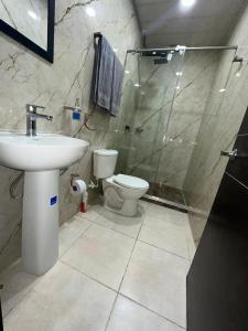 a bathroom with a toilet and a sink and a shower at Guatavita Loft - Apartamento in Guatavita