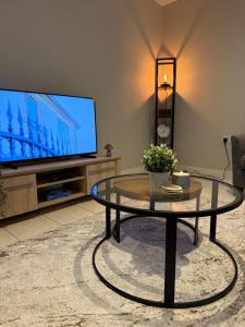 ein Wohnzimmer mit einem Couchtisch und einem Flachbild-TV in der Unterkunft School Path in Ironbridge