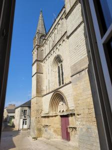 une vieille église avec une tour et une porte rouge dans l'établissement la petite montagne, à Le Puy-Notre-Dame