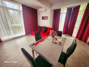 a living room with a table and a red couch at Luxury ApartHotel Alezzi Spa Resort Piscina Incalzita in Mamaia Nord